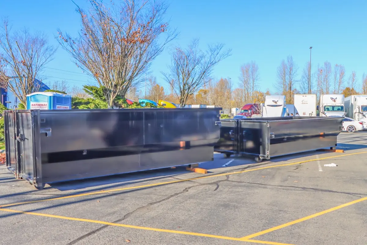 Professional dumpster rental service with roll-off container on residential driveway in Chelsea